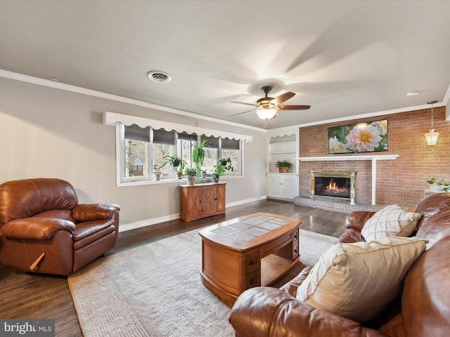 living room featuring ornamental molding, a brick fireplace, ceiling fan, and dark hardwood / wood-style flooring