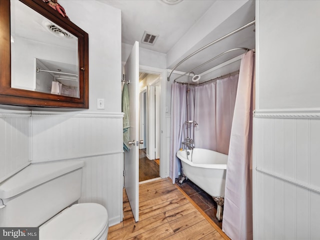 bathroom with shower / tub combo with curtain, toilet, and hardwood / wood-style floors