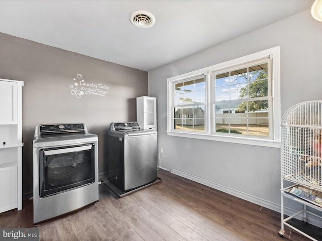 clothes washing area featuring hardwood / wood-style flooring and separate washer and dryer