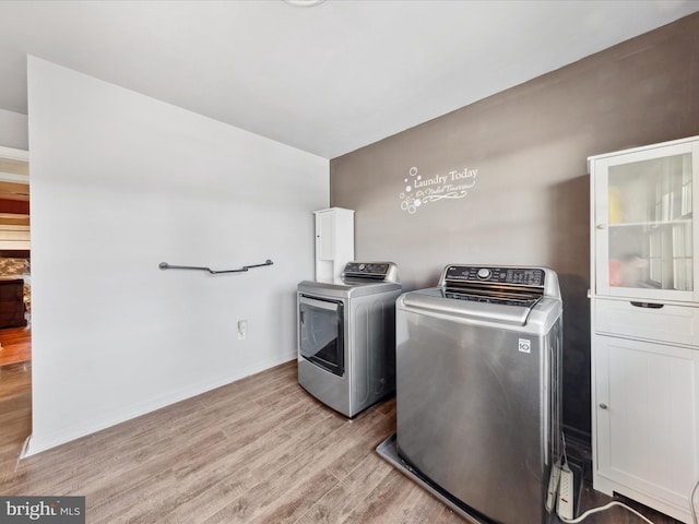 washroom with independent washer and dryer and light wood-type flooring