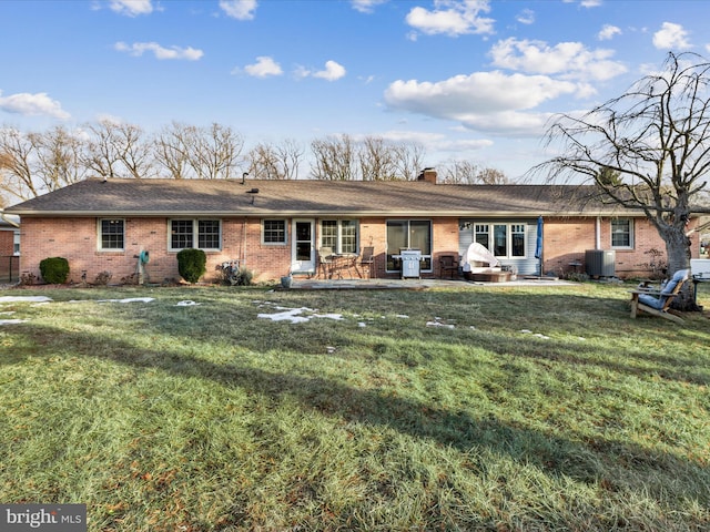 back of property with central AC, a lawn, and a patio