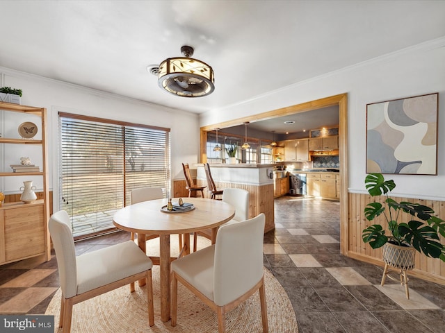 dining area featuring ornamental molding and wooden walls