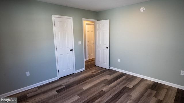 unfurnished bedroom with dark hardwood / wood-style floors