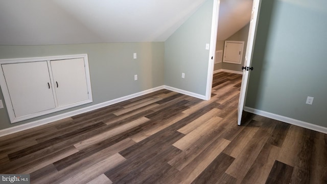 additional living space featuring vaulted ceiling and dark hardwood / wood-style floors