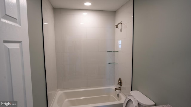 bathroom with toilet and tiled shower / bath combo