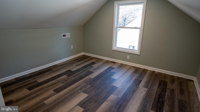 bonus room with dark wood-type flooring and vaulted ceiling