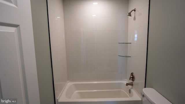 bathroom with toilet and tiled shower / bath