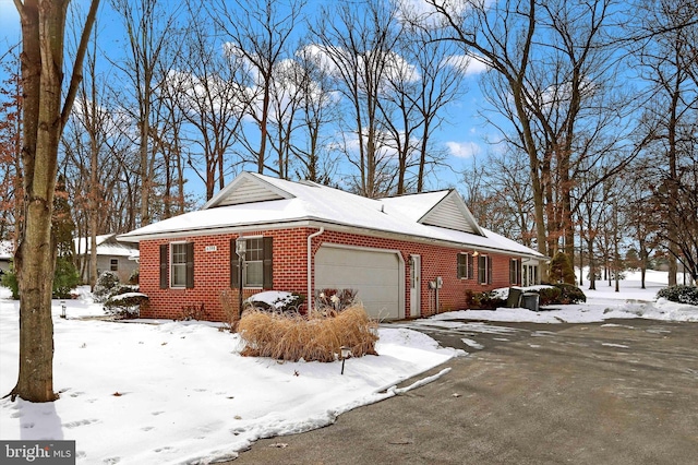 view of snowy exterior featuring a garage