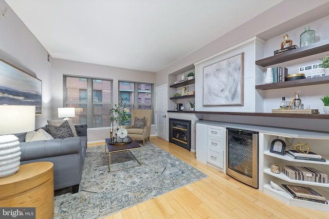 living room with beverage cooler and light hardwood / wood-style floors