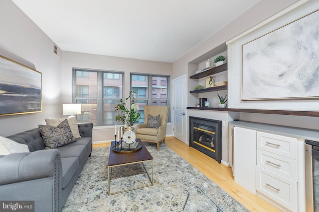 living room with beverage cooler and light wood-type flooring