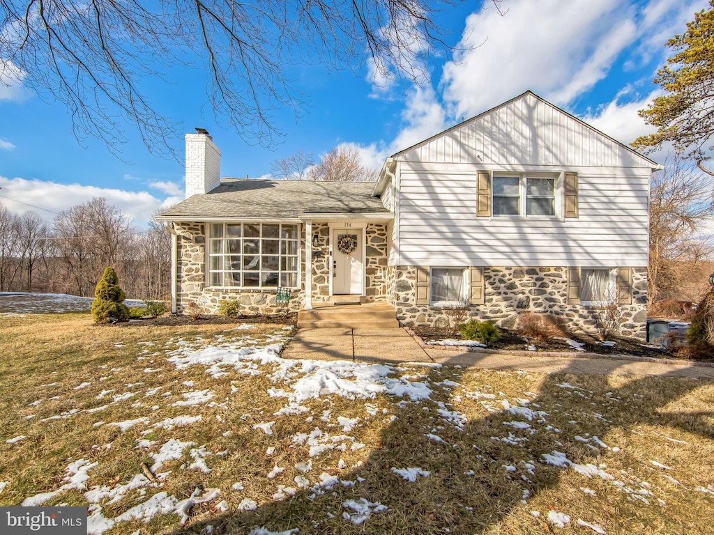 view of front of home with a yard and a sunroom