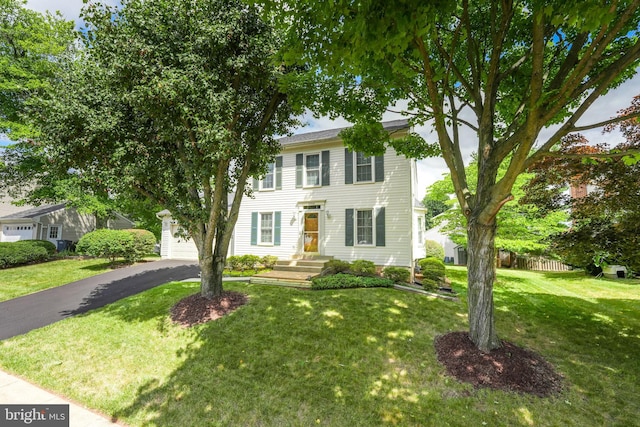 colonial inspired home with a garage and a front yard