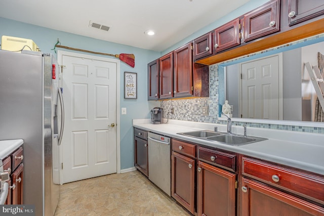 kitchen with sink, backsplash, and appliances with stainless steel finishes