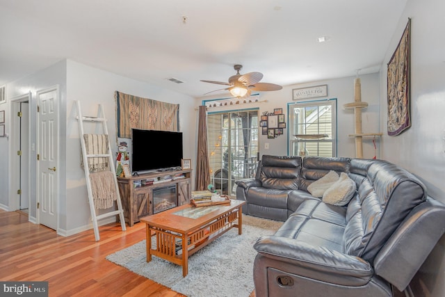 living room with ceiling fan and light wood-type flooring