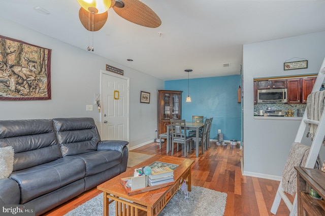 living room with ceiling fan and dark hardwood / wood-style flooring