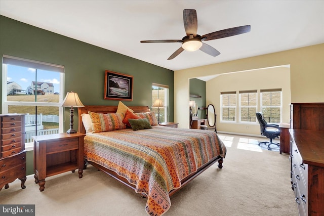 bedroom featuring vaulted ceiling, light colored carpet, and ceiling fan