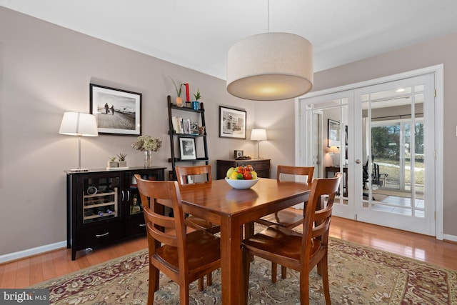 dining room featuring french doors and light hardwood / wood-style flooring