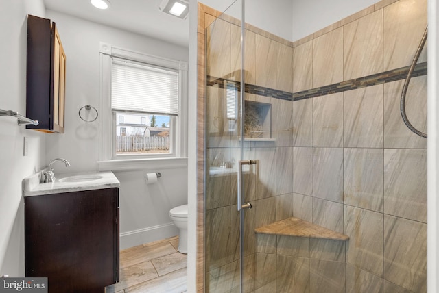 bathroom featuring vanity, toilet, and a shower with shower door