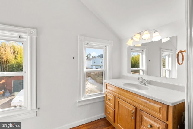 bathroom with vanity, vaulted ceiling, and hardwood / wood-style floors