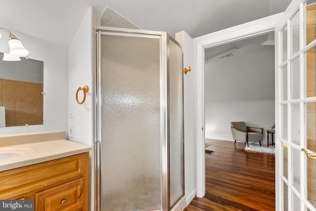 bathroom with vanity, hardwood / wood-style flooring, french doors, and walk in shower