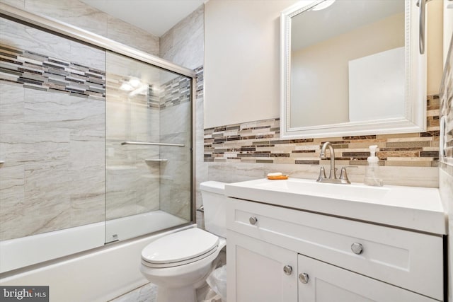 full bathroom featuring toilet, vanity, and bath / shower combo with glass door