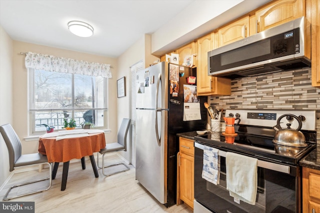 kitchen with tasteful backsplash and appliances with stainless steel finishes