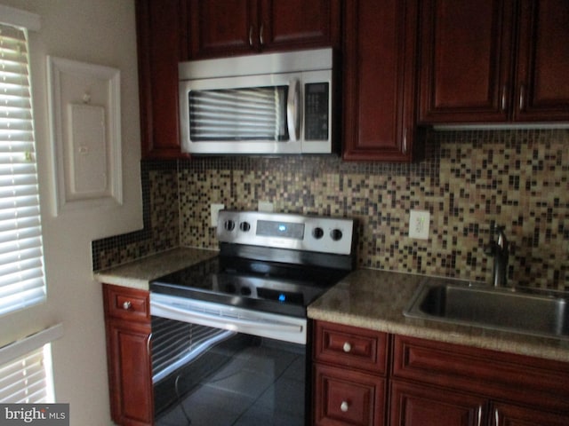 kitchen with stainless steel appliances, sink, tile patterned floors, and decorative backsplash