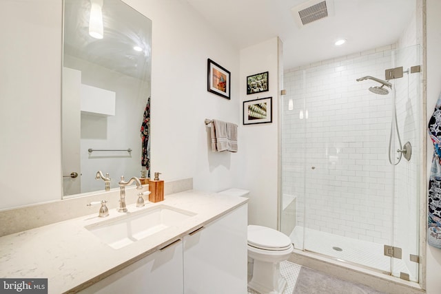 bathroom with toilet, vanity, visible vents, tile patterned floors, and a stall shower