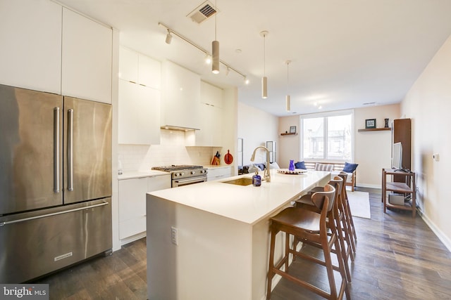 kitchen with modern cabinets, decorative backsplash, stainless steel appliances, and a sink