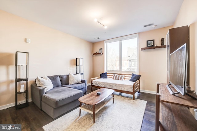 living room featuring baseboards, visible vents, and dark wood-type flooring