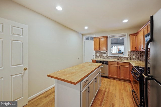 kitchen featuring wood counters, dishwasher, sink, a center island, and black range with gas cooktop