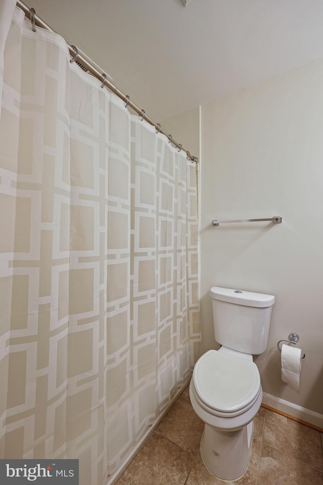 bathroom featuring toilet and a shower with shower curtain