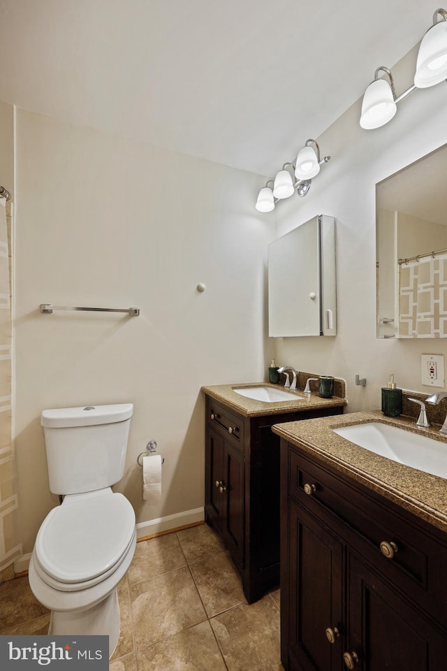 bathroom featuring tile patterned floors, toilet, and vanity