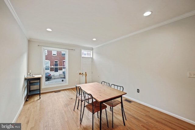 dining room featuring crown molding and light wood-type flooring