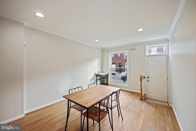 dining area with ornamental molding and light wood-type flooring