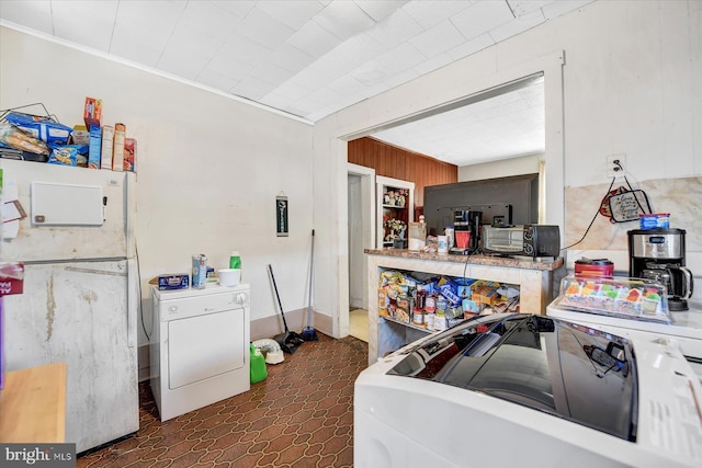 kitchen featuring washer / clothes dryer, crown molding, white fridge, and wood walls