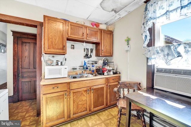 kitchen with light parquet flooring, sink, cooling unit, and a drop ceiling