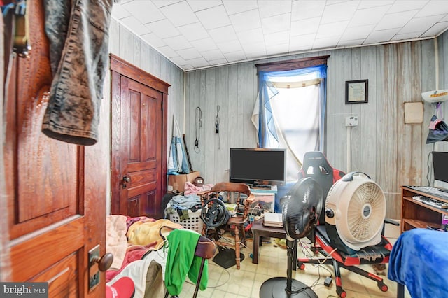 bedroom featuring wooden walls