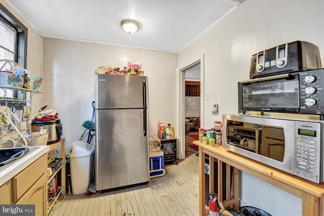 kitchen featuring light wood-type flooring and appliances with stainless steel finishes