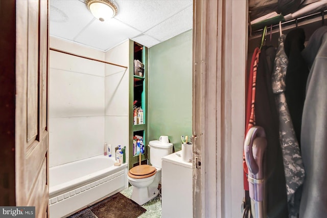 bathroom with shower / bathing tub combination, a paneled ceiling, and toilet