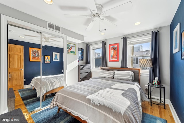 bedroom featuring ceiling fan, a closet, and light hardwood / wood-style flooring