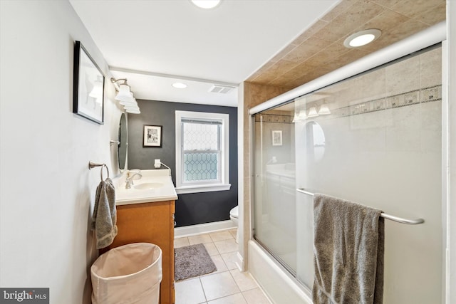 full bathroom with tile patterned flooring, vanity, bath / shower combo with glass door, and toilet