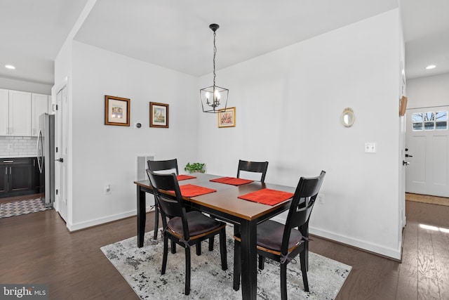 dining room with dark hardwood / wood-style floors and a chandelier