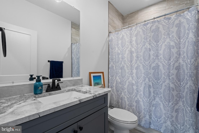 bathroom featuring vanity, curtained shower, and toilet