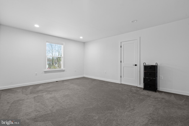 unfurnished room with dark colored carpet