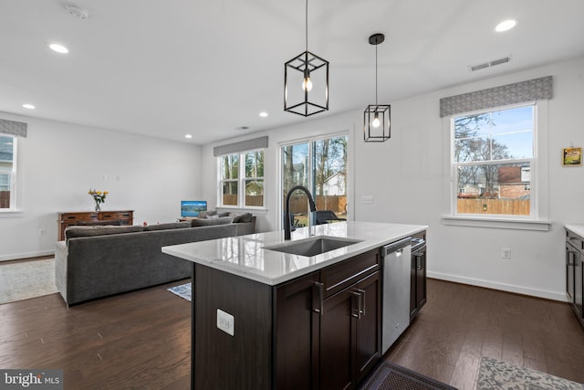 kitchen with dishwasher, sink, dark hardwood / wood-style flooring, hanging light fixtures, and a kitchen island with sink