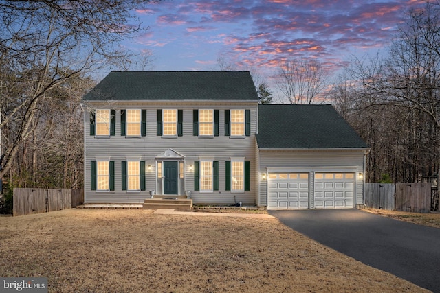 colonial house with a garage and a yard