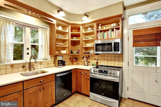 kitchen featuring appliances with stainless steel finishes, sink, light tile patterned floors, and decorative backsplash