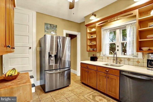 kitchen with butcher block counters, sink, light tile patterned floors, appliances with stainless steel finishes, and decorative backsplash