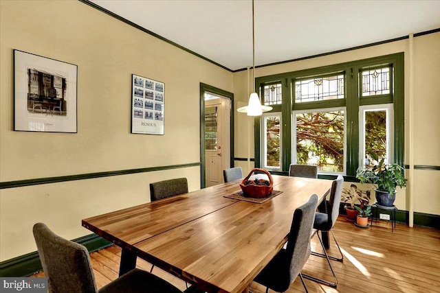 dining room featuring ornamental molding and light hardwood / wood-style floors